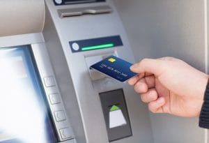 man puts credit card into ATM